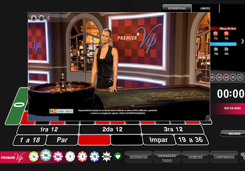 La crupier de la Ruleta Premier VIP con los controles del juego, la rueda, y el tapete al fondo.