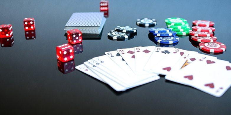 Cartas de juego, dados y fichas de casino en una mesa