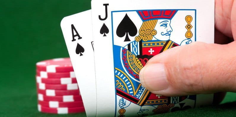 Una mano de dos cartas y fichas de casino