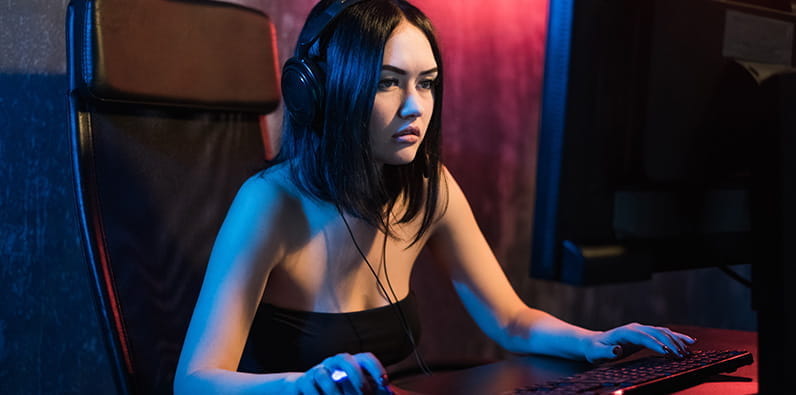 Una chica morena sentada delante de un ordenador.