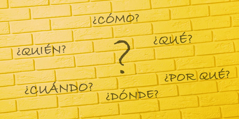 Un muro dibujado con las palabras 'quién', 'cómo', 'qué', 'por qué', 'dónde', 'cuándo'