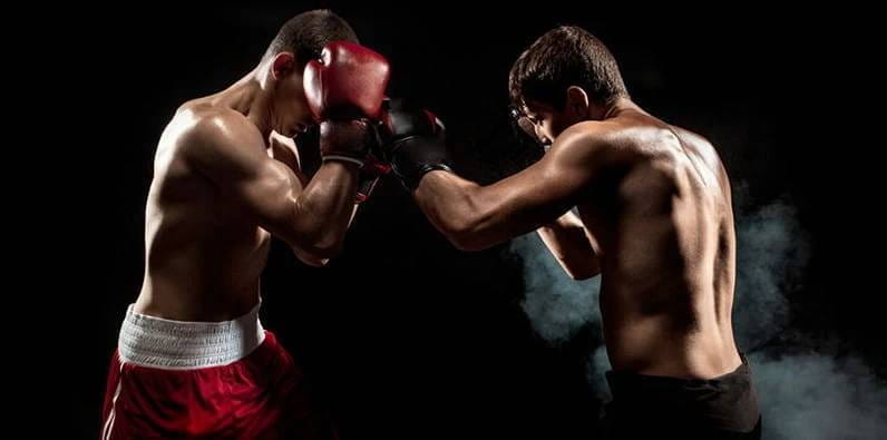 Un boxeador se defiende de un ataque de su oponente