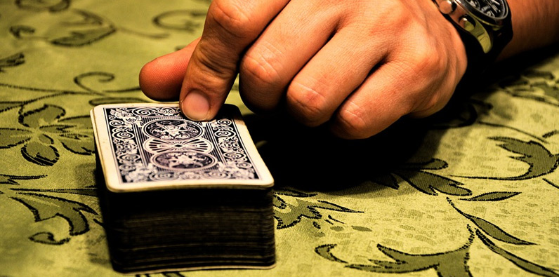 Un dedo puesto encima de un mazo de cartas