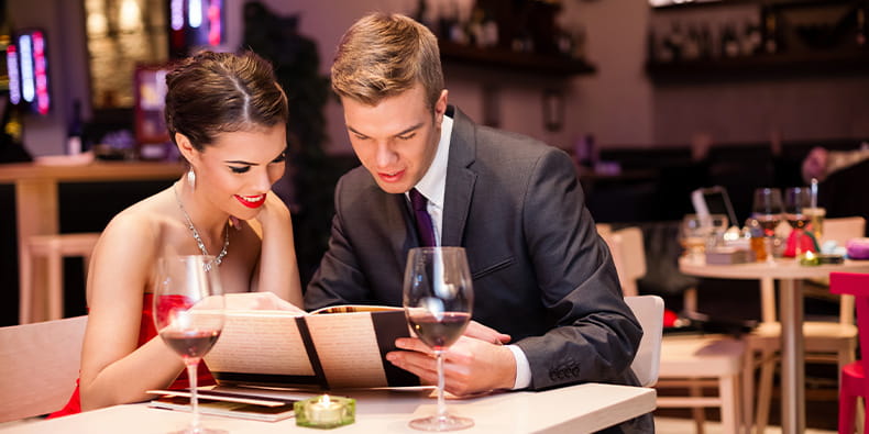 Una pareja eligiendo menú en un restaurante. 