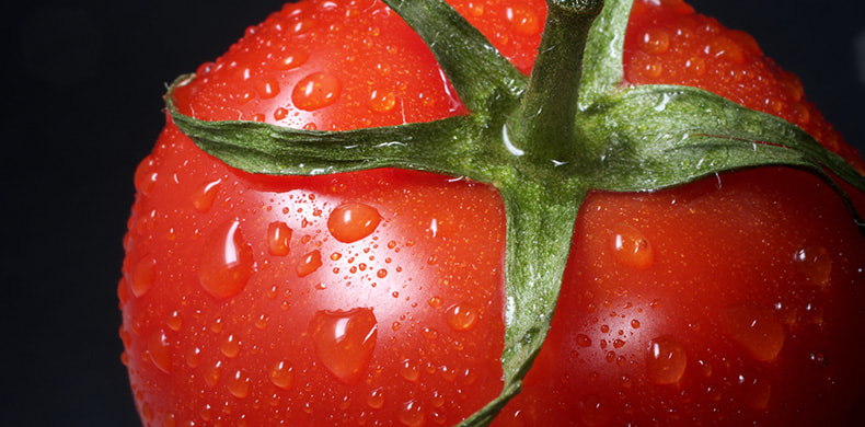 Primer plano de un tomate canario con gotas de agua. 
